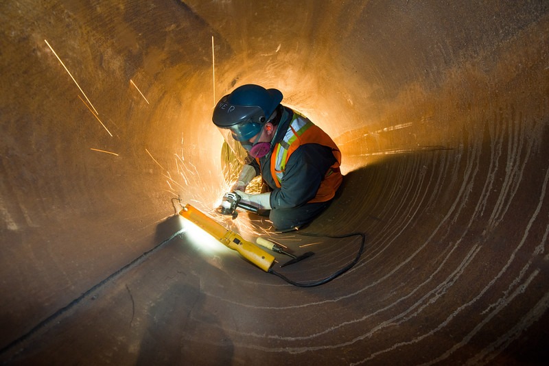 Welder working inside a large-diameter pipe
