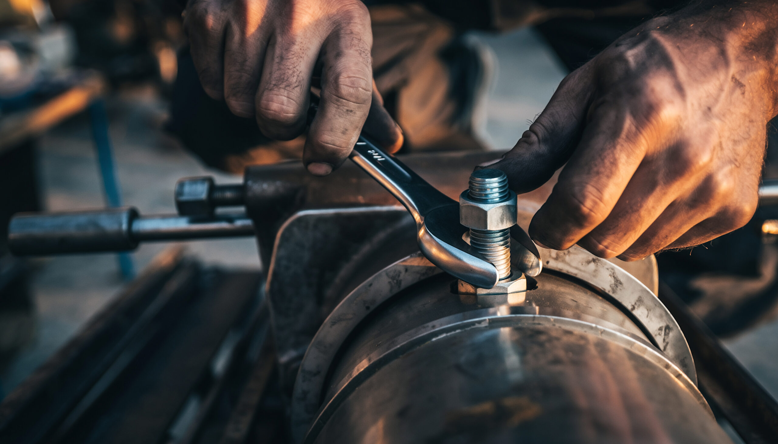 Tradesperson tightening a pipe fitting with a wrench