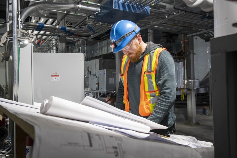 Tradesperson reviewing technical drawings